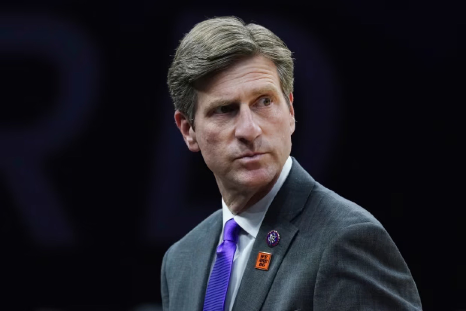 Rep. Greg Stanton in a gray suit glancing sideways against a dark background